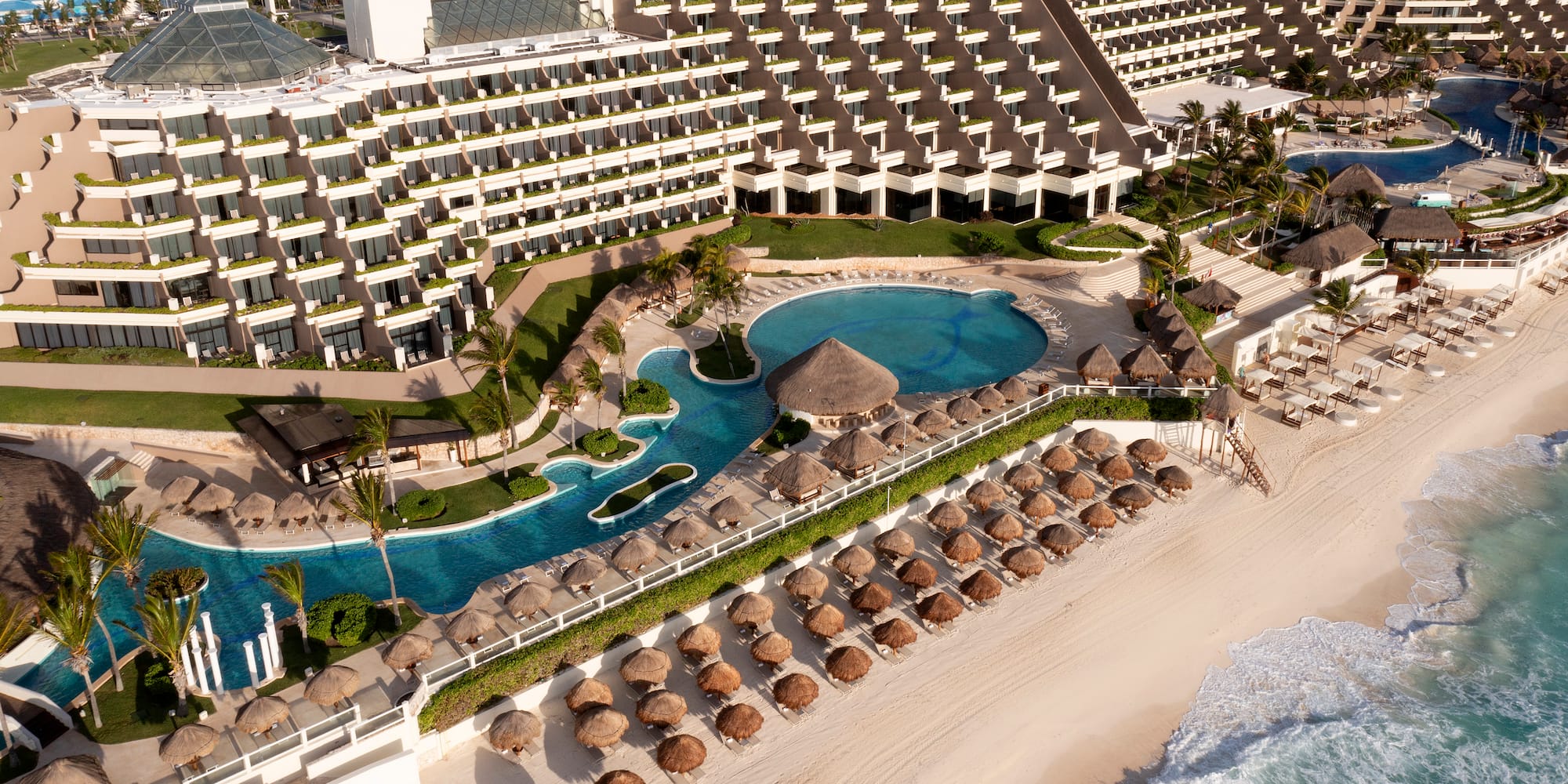 a swimming pool and a beach with umbrellas