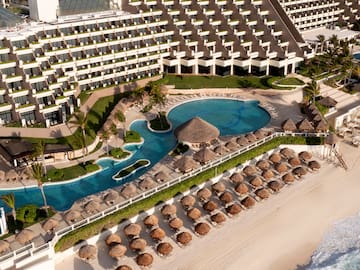 a swimming pool and a beach with umbrellas