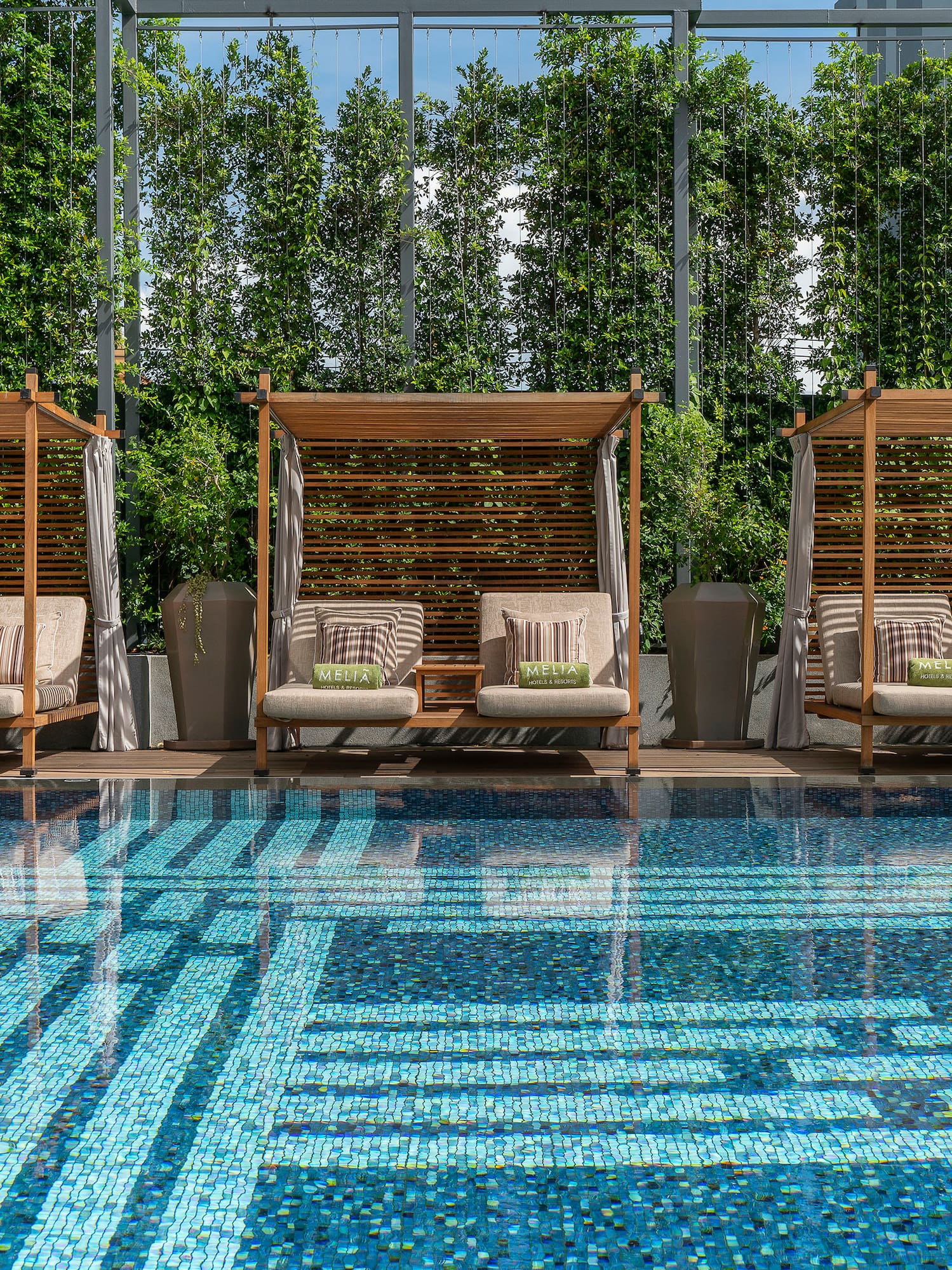 a pool with chairs and a large glass wall