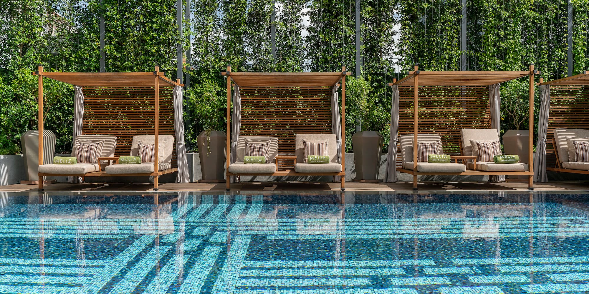 a pool with chairs and a large glass wall