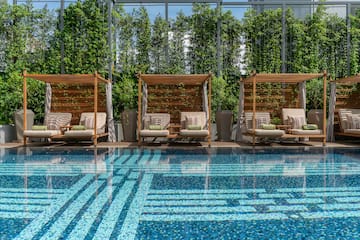 a pool with chairs and a large glass wall