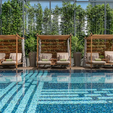 a pool with chairs and a large glass wall