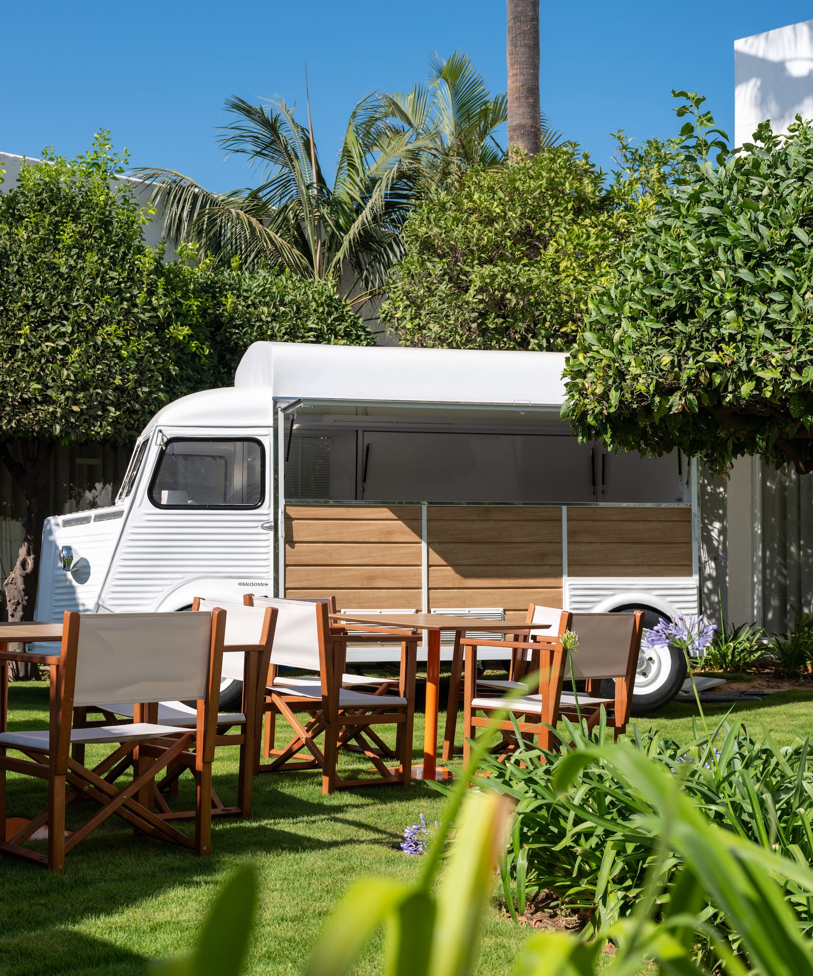 a white van with chairs and tables in a yard
