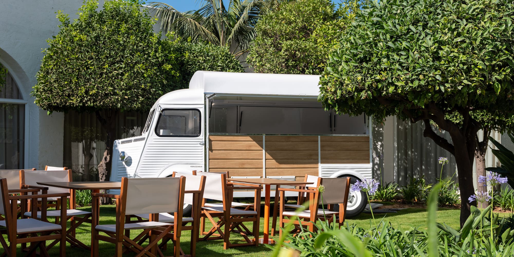 a white van with chairs and tables in a yard