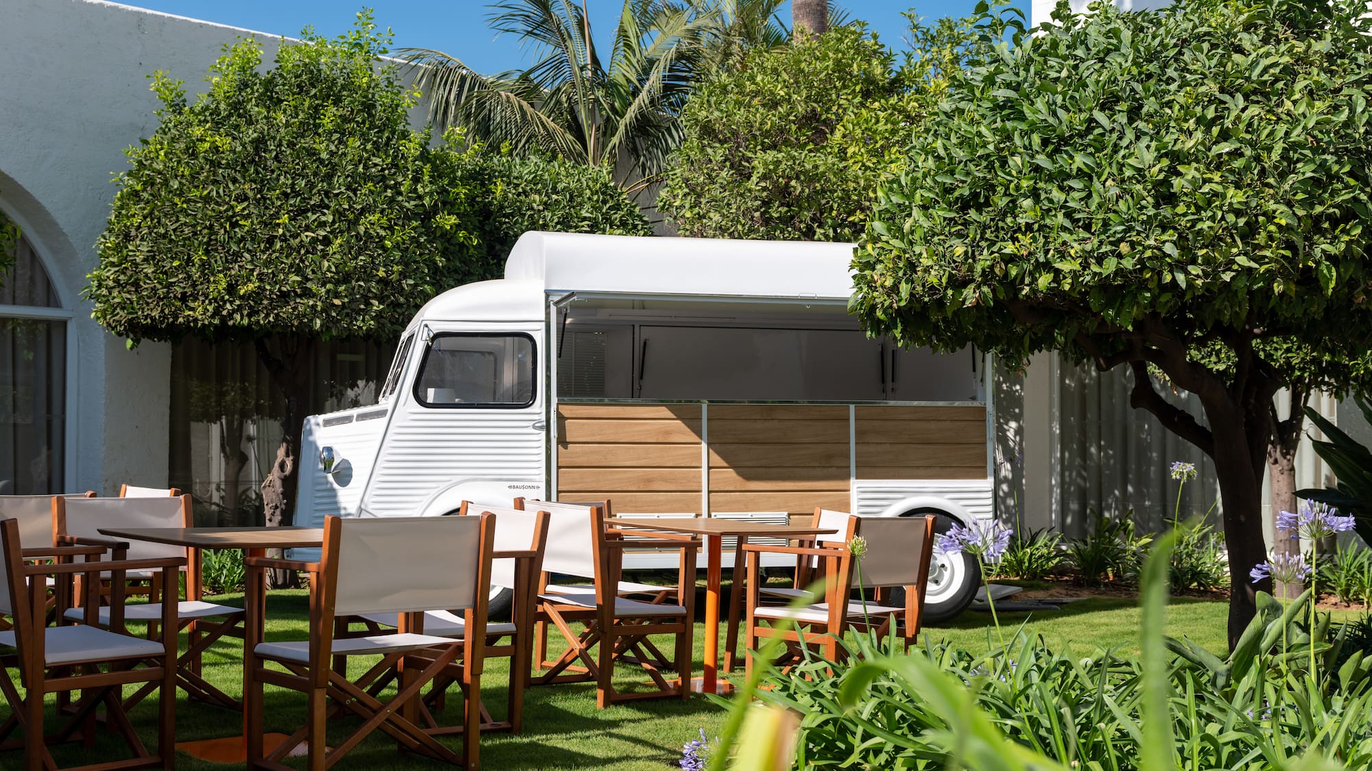 a white van with chairs and tables in a yard
