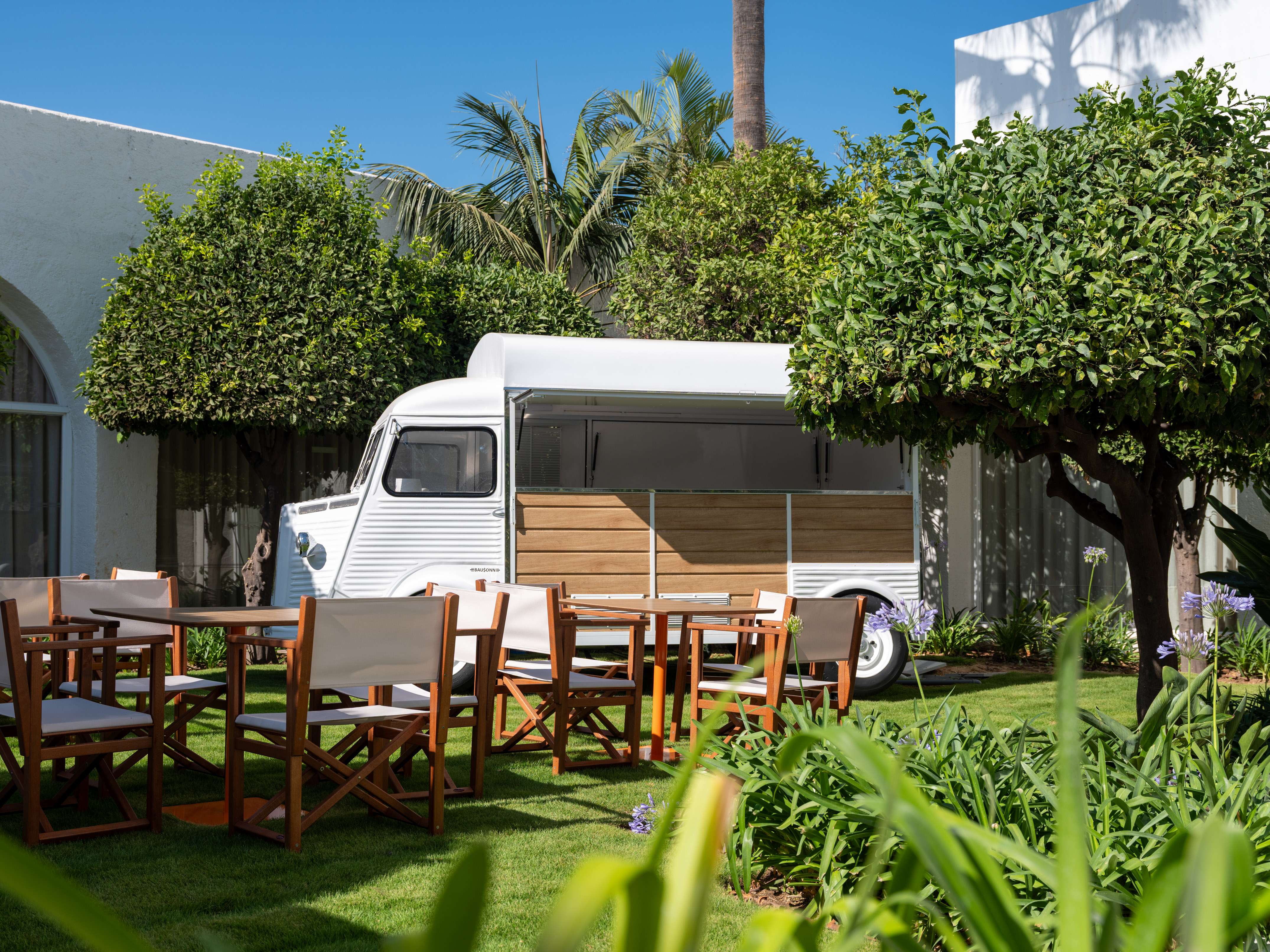 a white van with chairs and tables in a yard