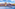 Valletta, Malta cityscape from water, with sailing boat, dome, and spire.
