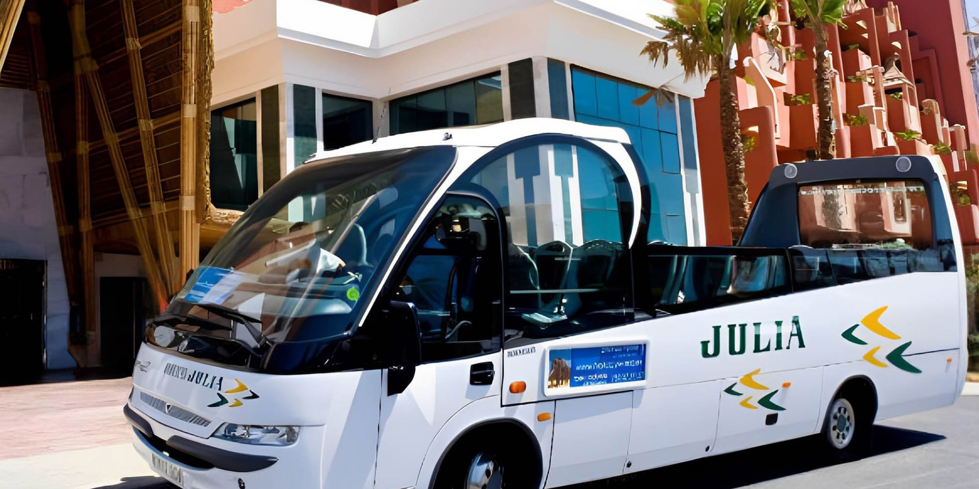 a white bus parked in front of a building