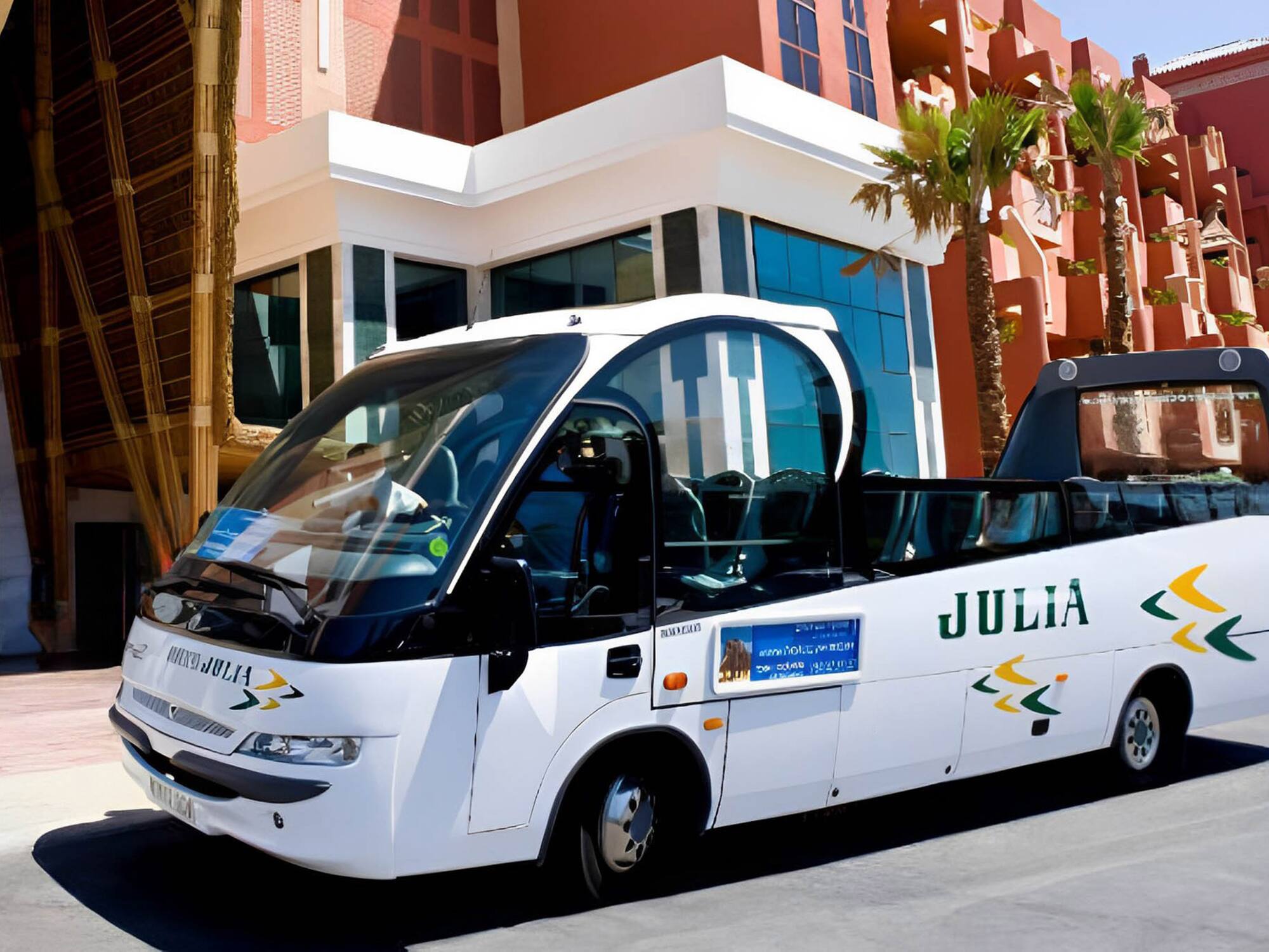a white bus parked in front of a building
