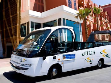 a white bus parked in front of a building