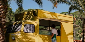 a woman standing in front of a food truck