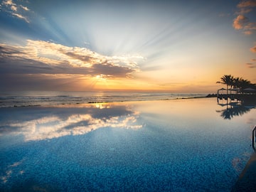 a pool with a body of water and a sunset