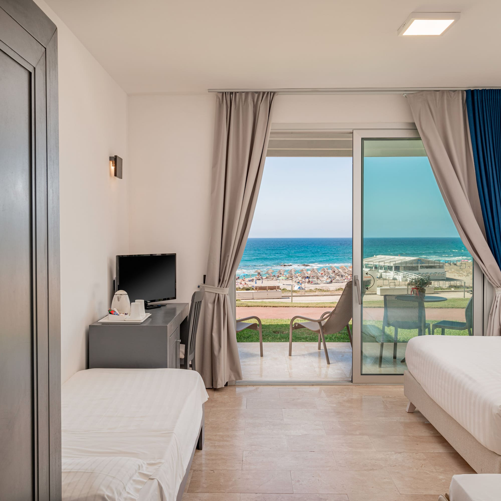 a room with two beds and a sliding glass door