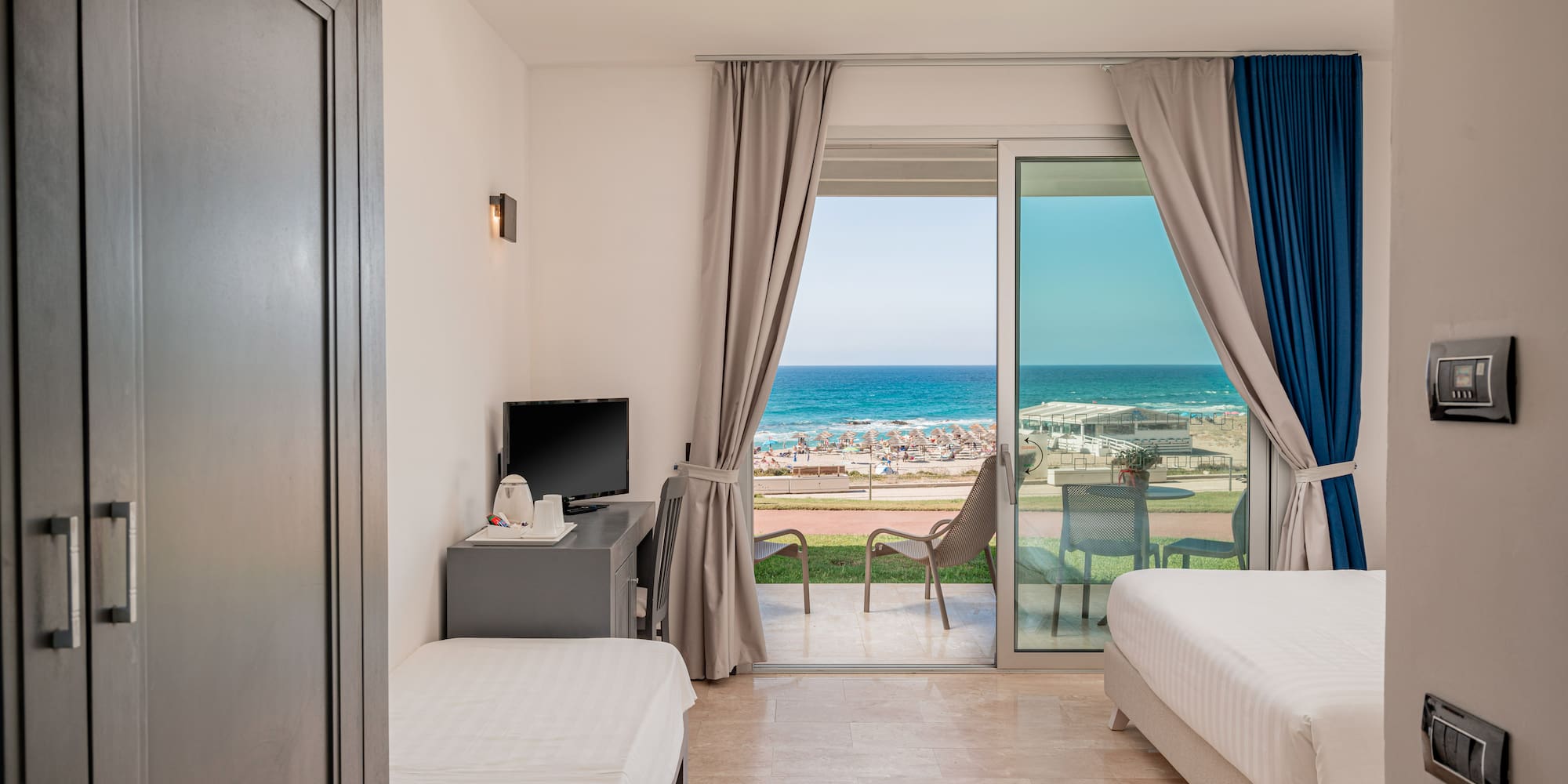 a room with two beds and a sliding glass door