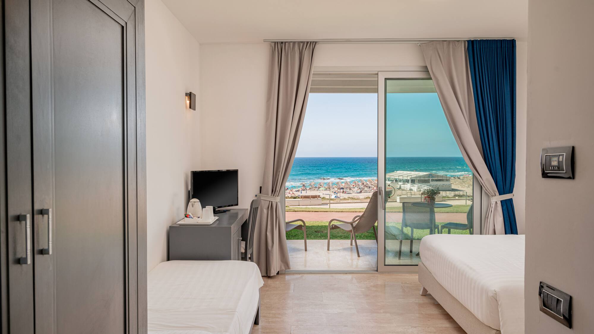 a room with two beds and a sliding glass door