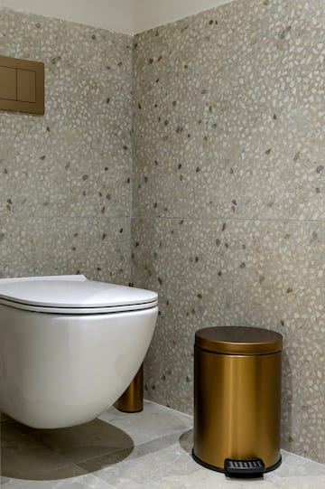 a toilet and trash can in a bathroom