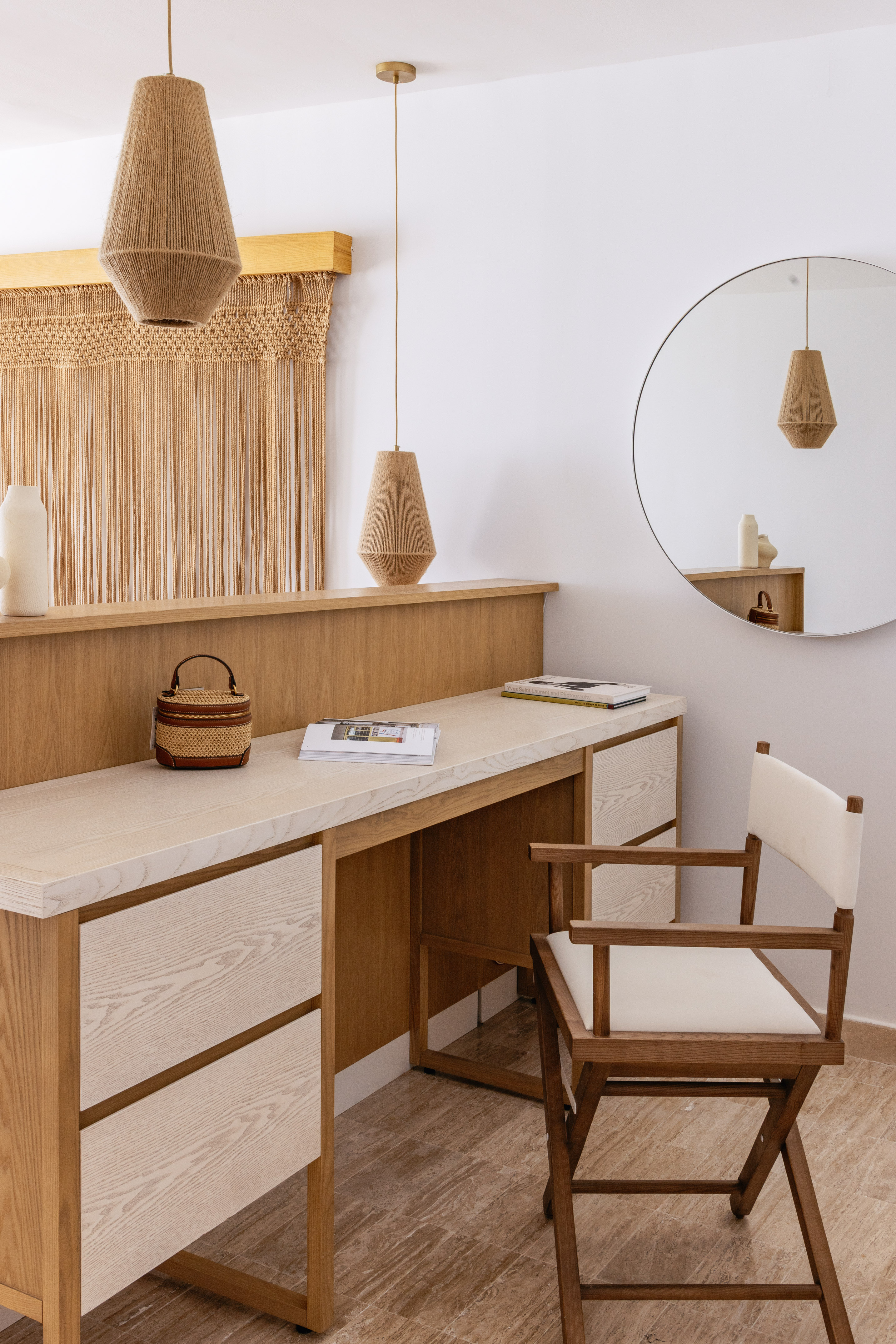 Modern wooden vanity, macrame wall art, woven pendant lights, and round mirror.