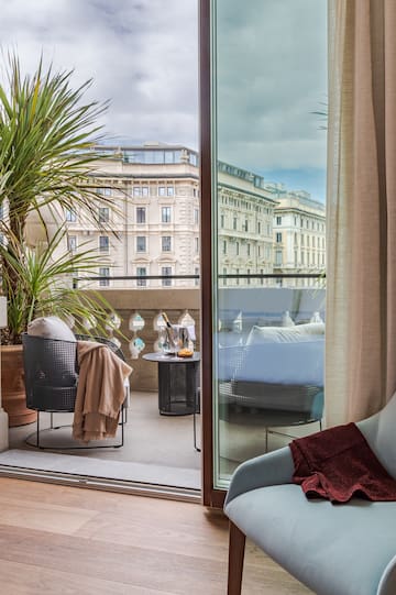 a room with a glass door and a balcony with a plant and a window