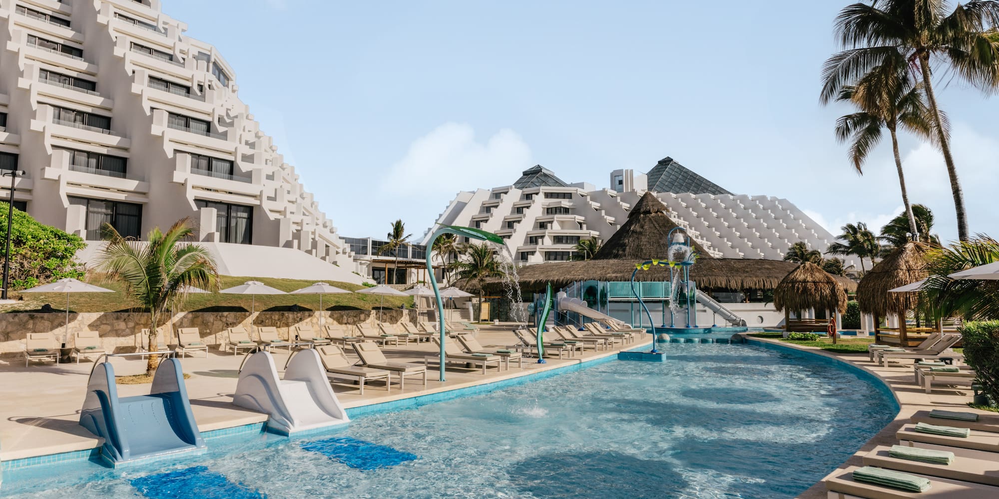Pyramid-style hotel resort with pool, water slides, and palm trees.