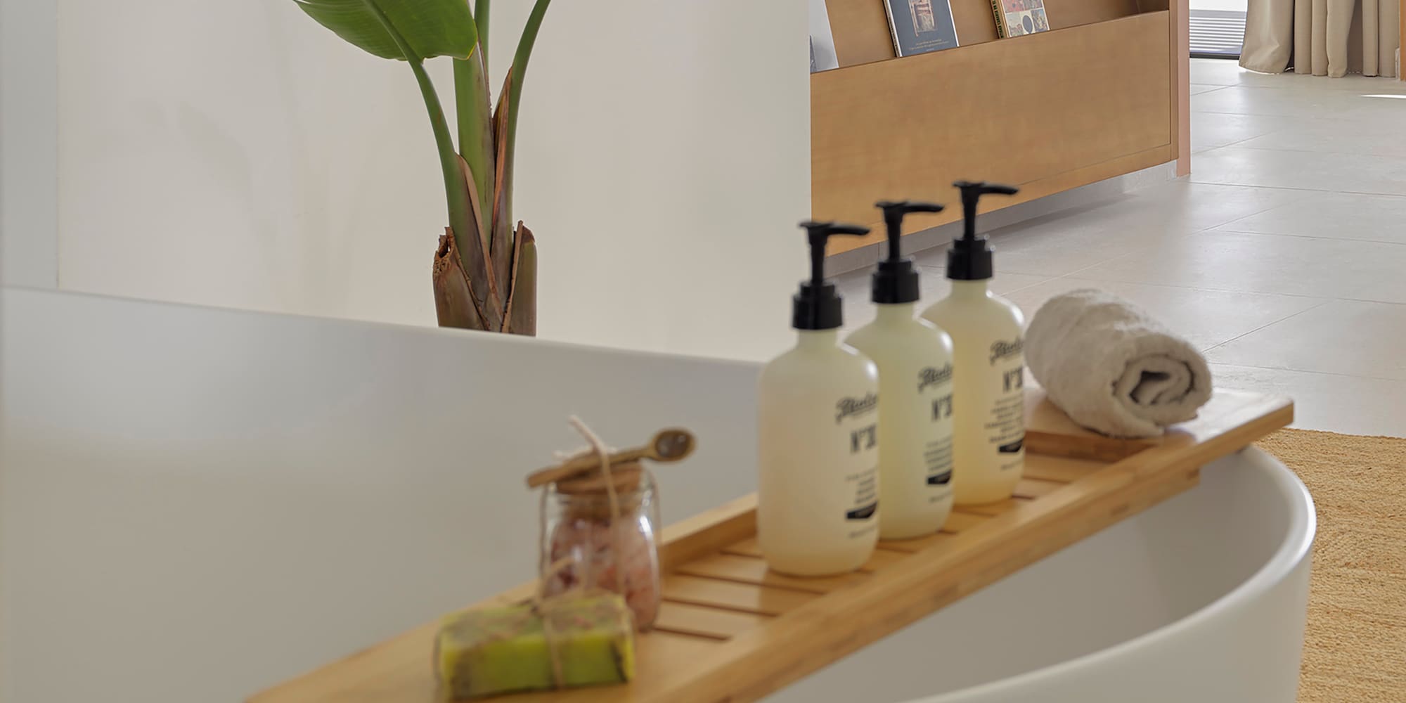 a bathtub with bottles of soap and a towel on it
