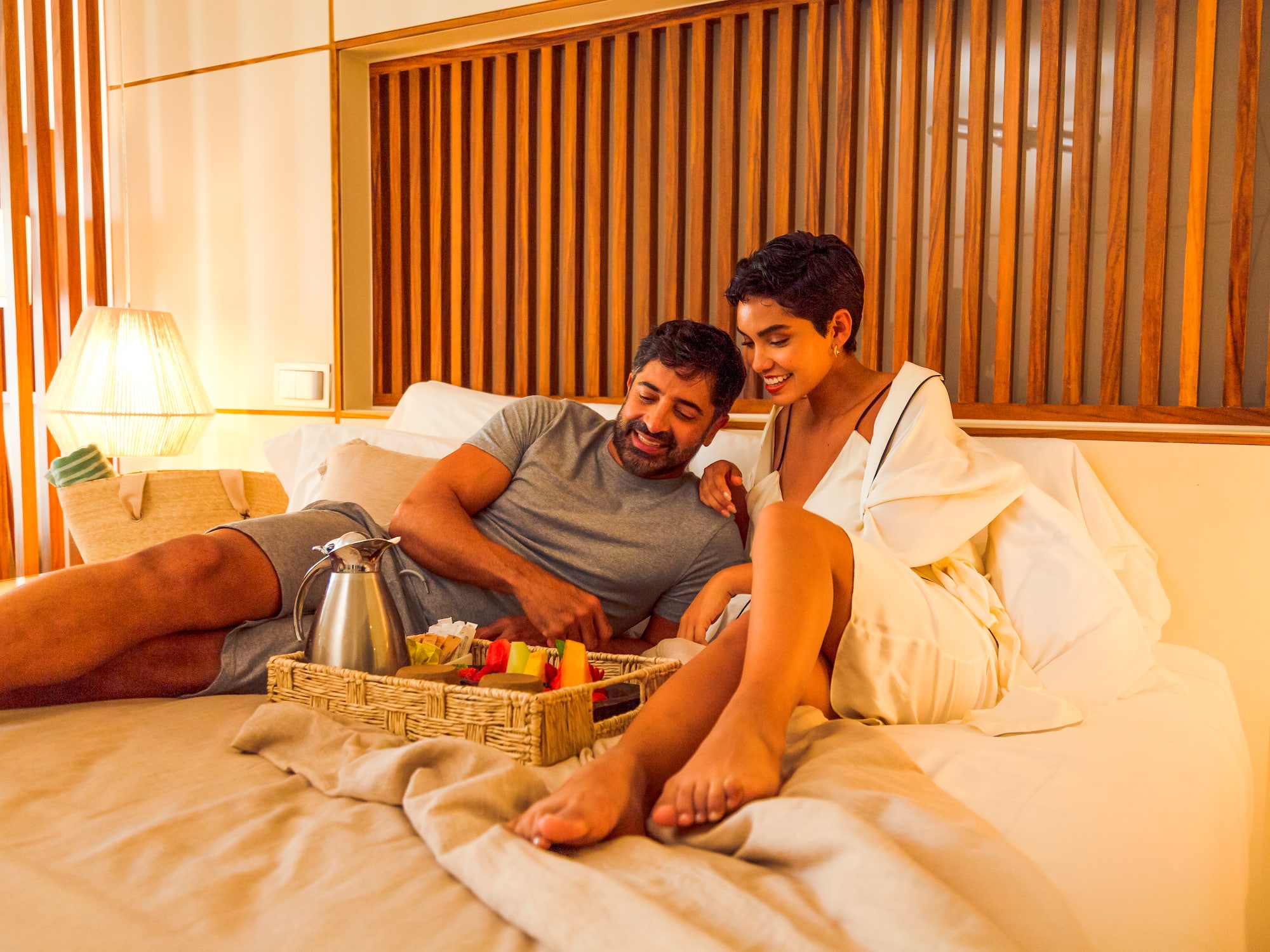 a man and woman sitting on a bed