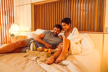 a man and woman sitting on a bed