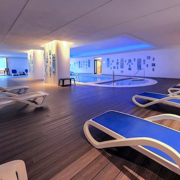 a pool with lounge chairs and a pool