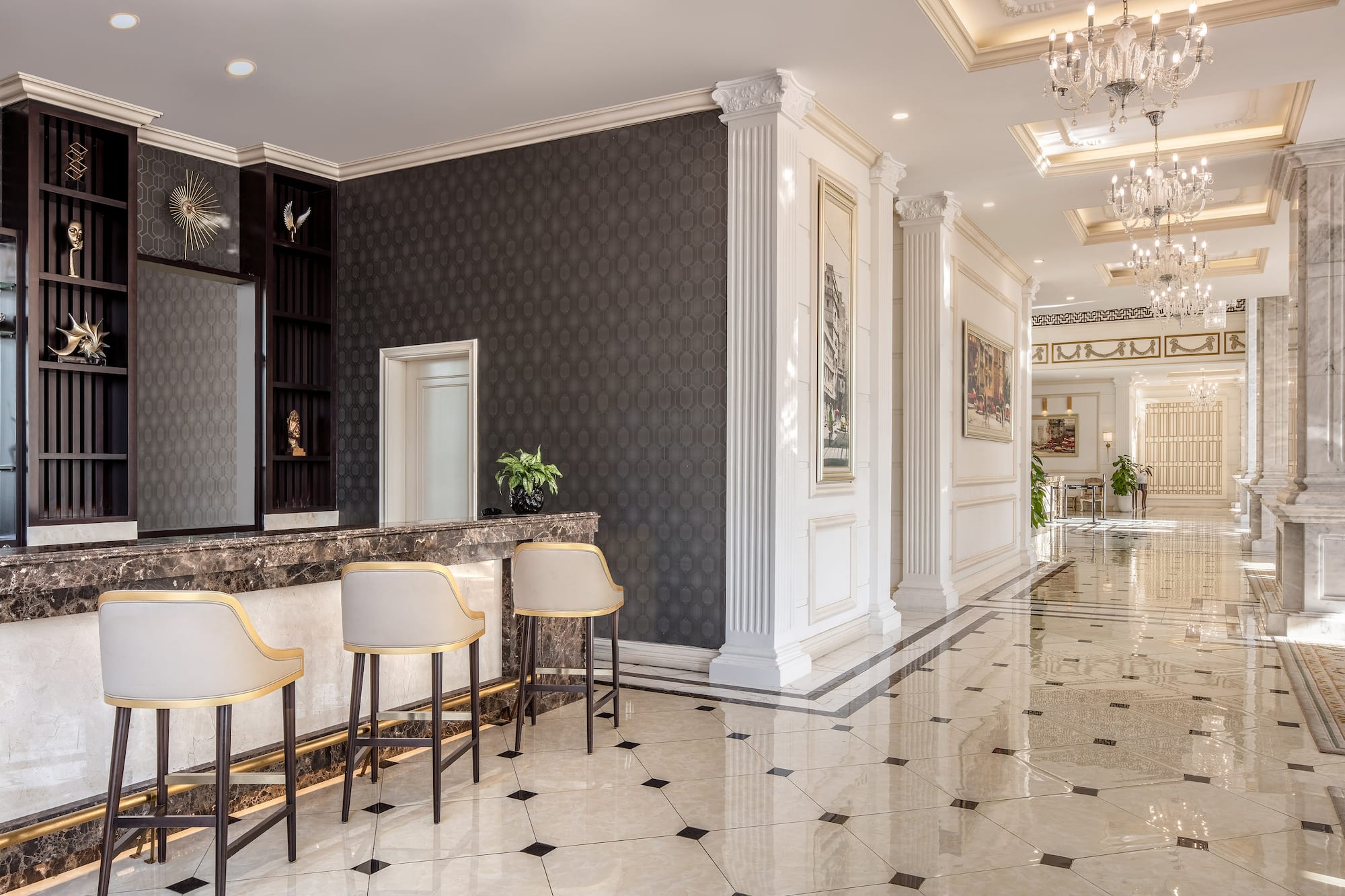 Luxurious hotel lobby with reception bar, elegant stools, marble, classic columns.