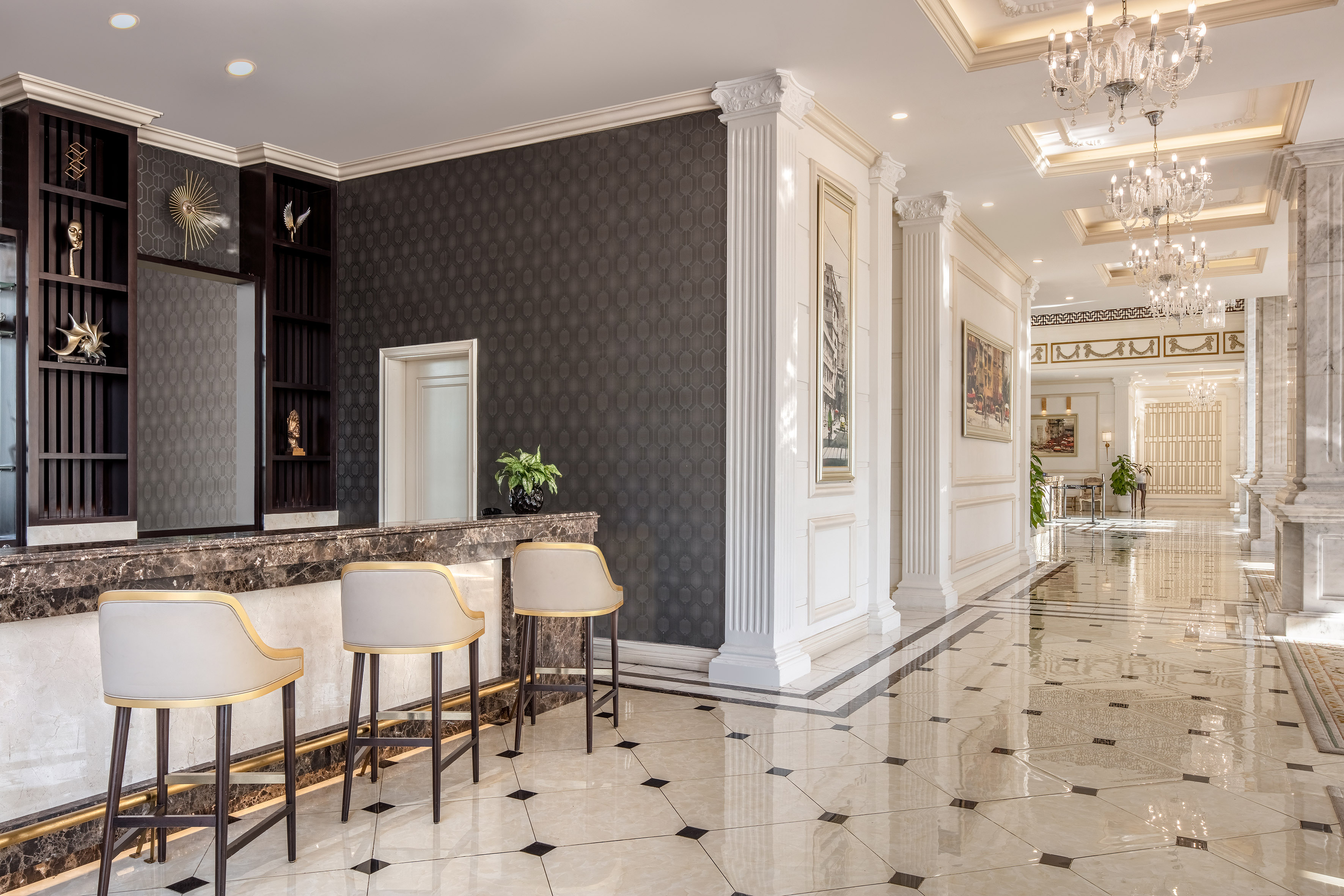 Luxurious hotel lobby with reception bar, elegant stools, marble, classic columns.