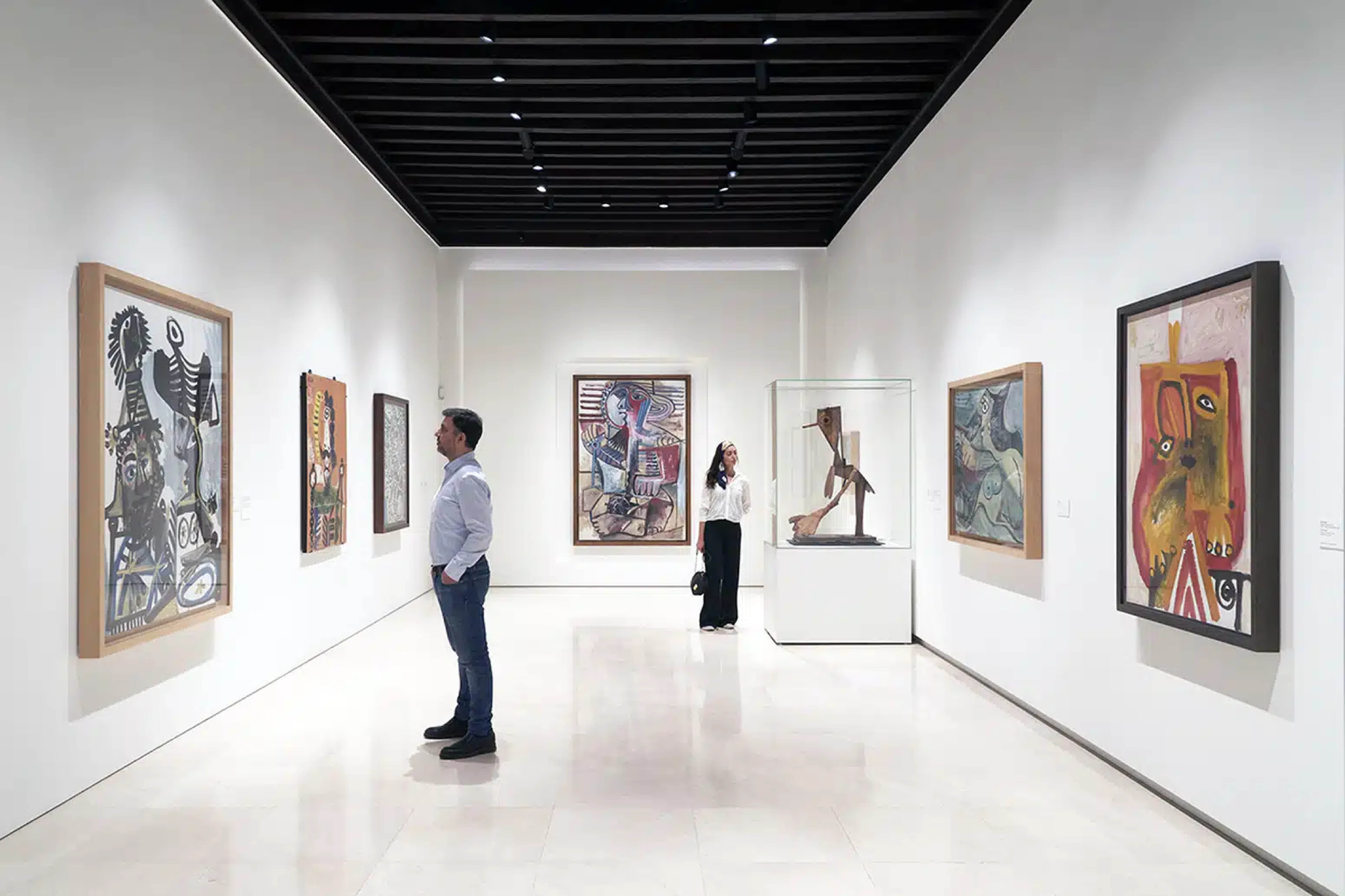 a man and woman looking at art on a wall