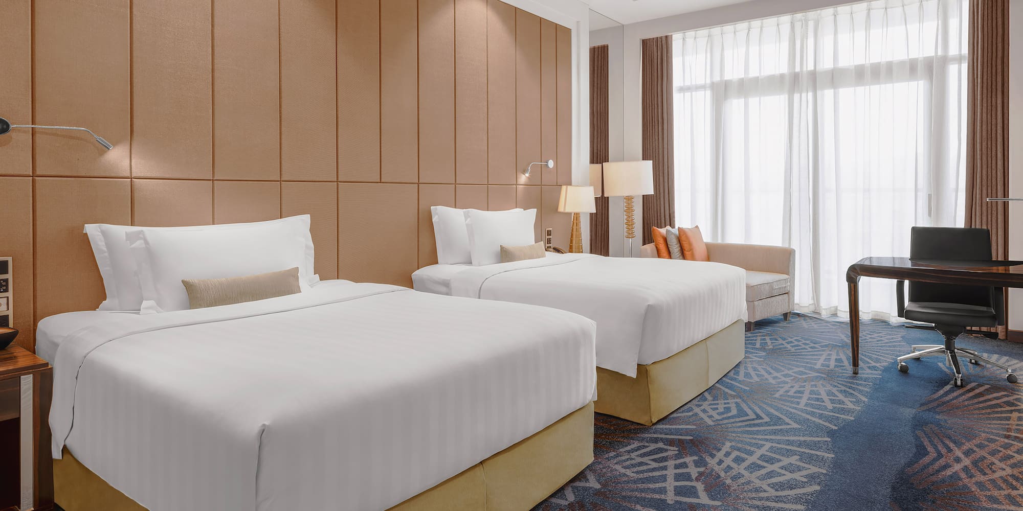 a room with two beds and a chair