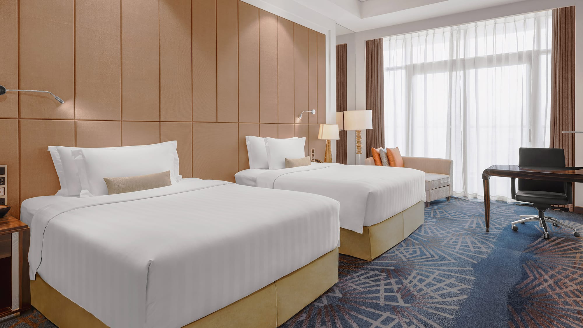 a room with two beds and a chair