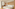 Modern hotel bedroom with white bed, wood accents, and freestanding tub.