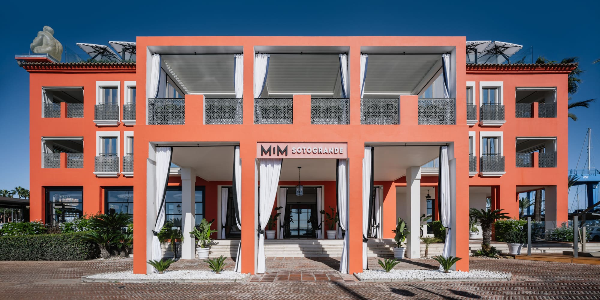 a building with white curtains and a brick walkway