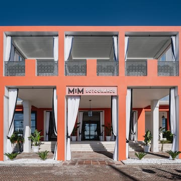 a building with white curtains and a brick walkway