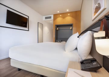 a bed with a telephone and a phone on a desk