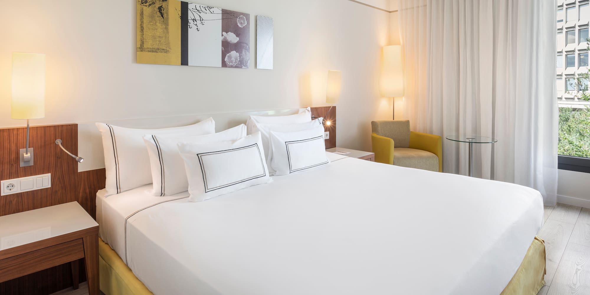 a bed with white sheets and pillows in a room