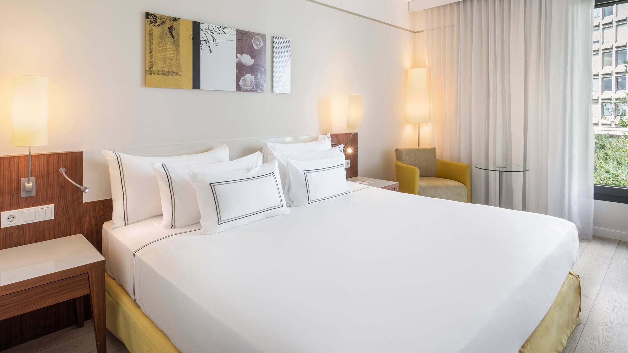 a bed with white sheets and pillows in a room