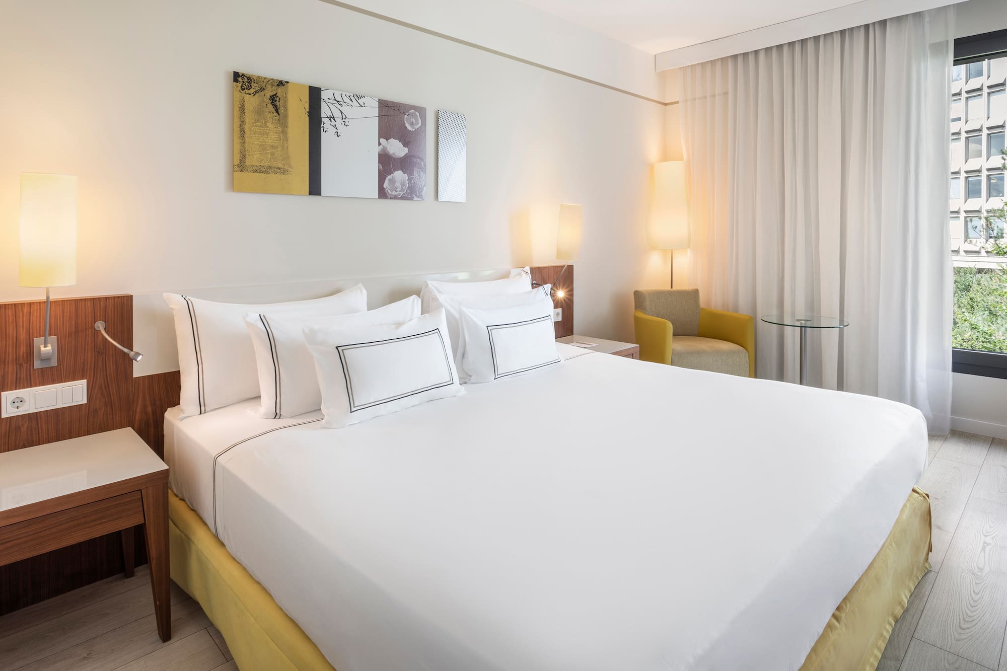 a bed with white sheets and pillows in a room