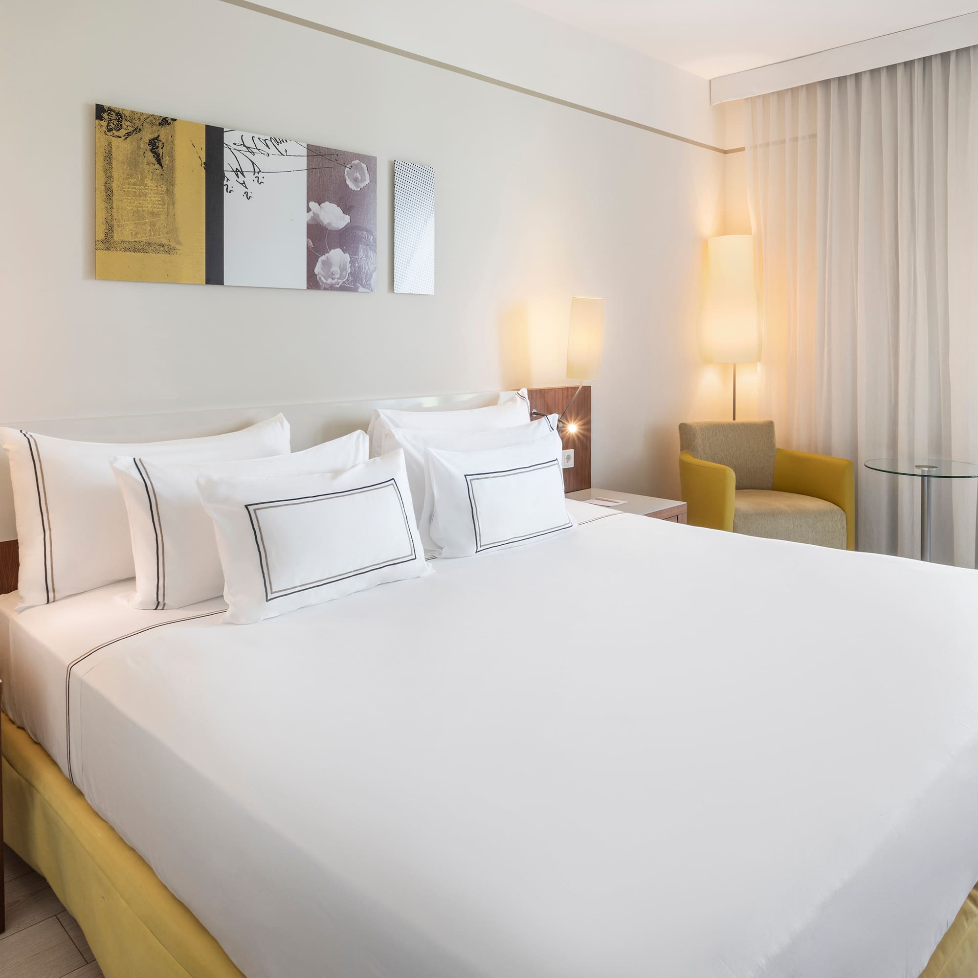 a bed with white sheets and pillows in a room