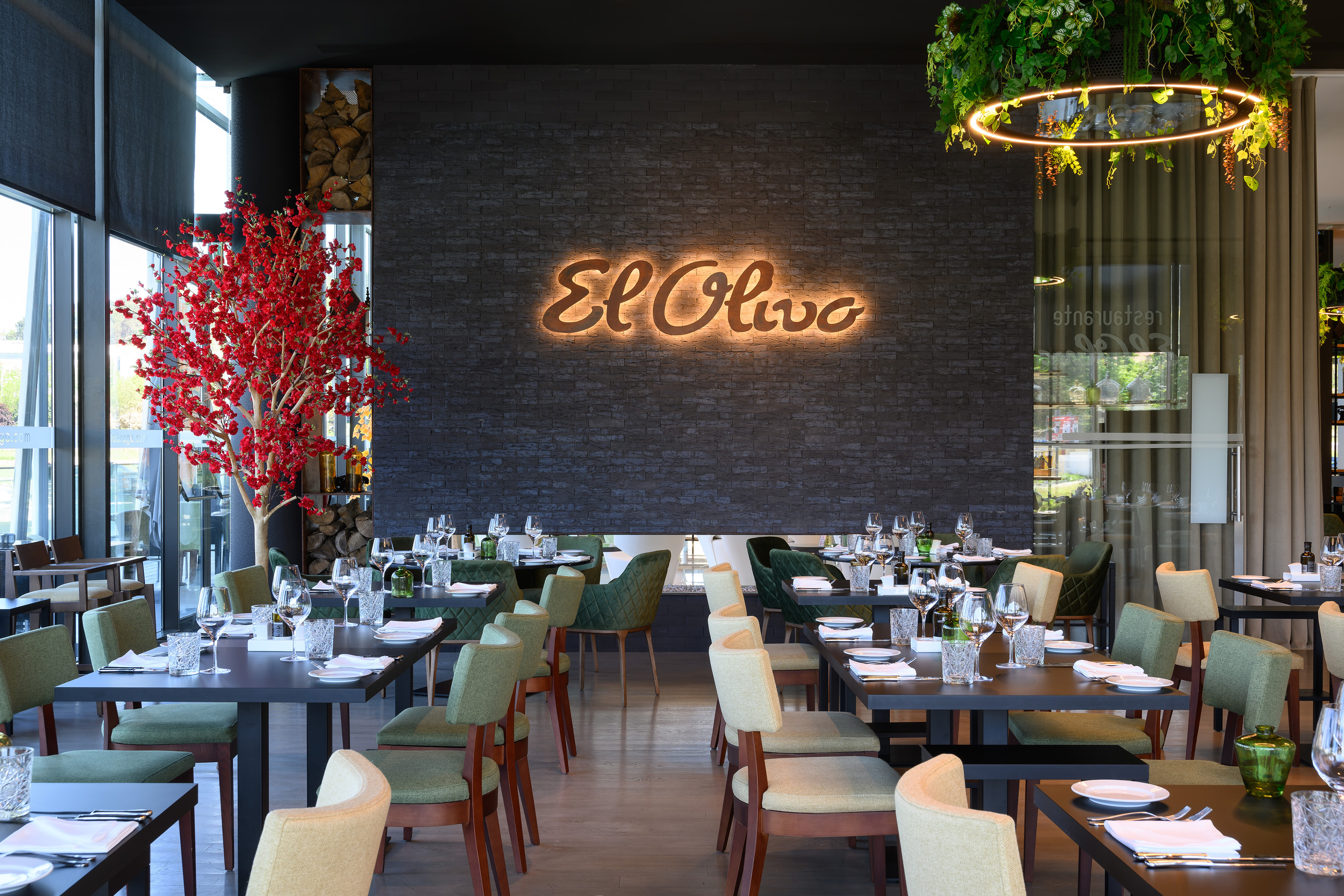 "El Olivo" restaurant interior: modern dining, glowing sign, red tree.