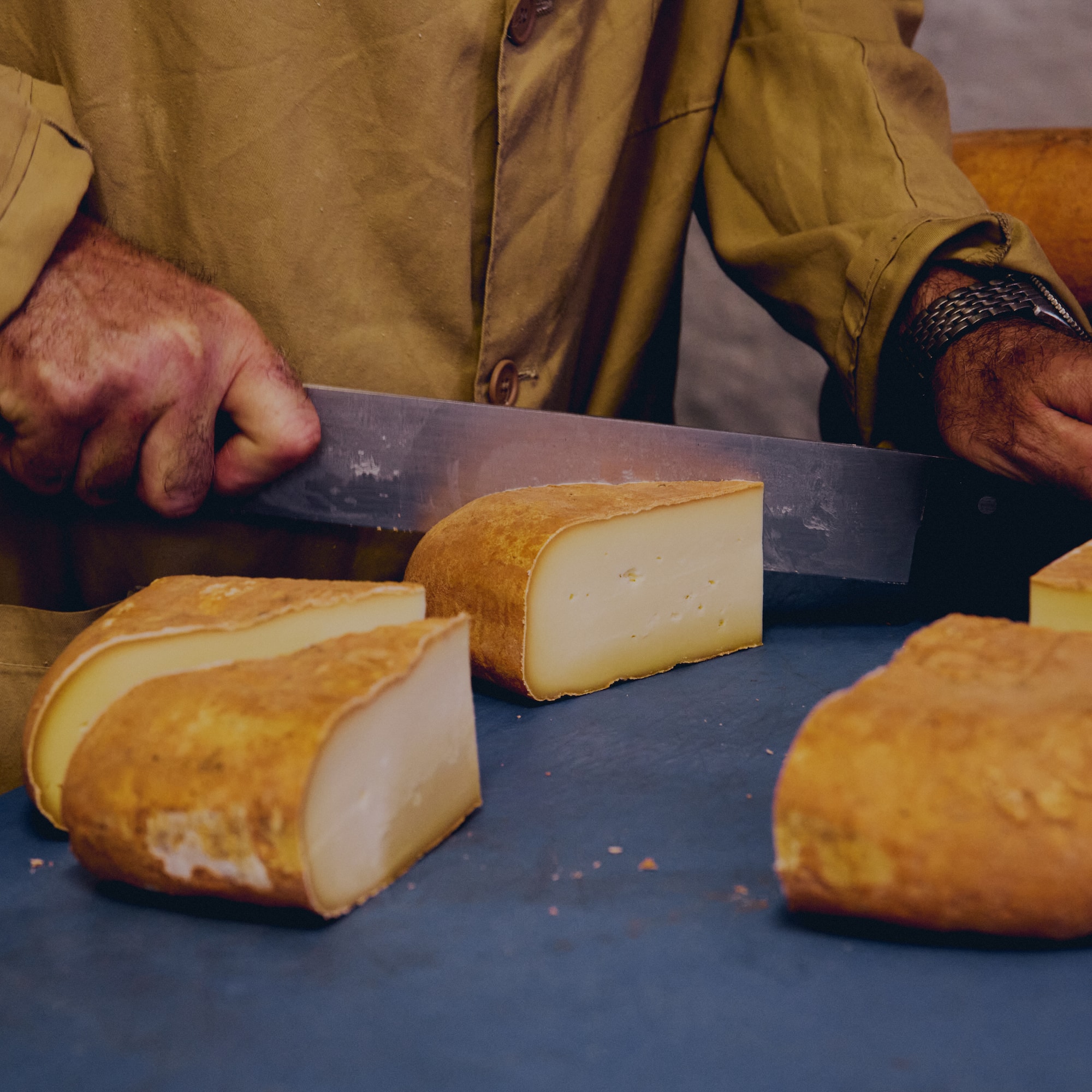 a person cutting a piece of cheese