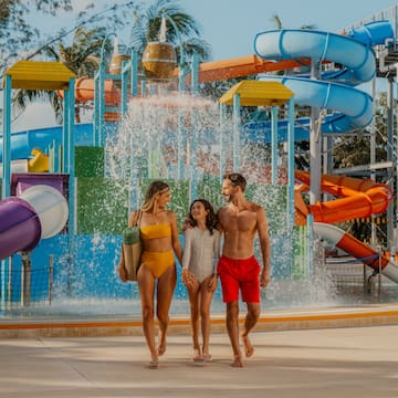 a group of people walking in front of a water park