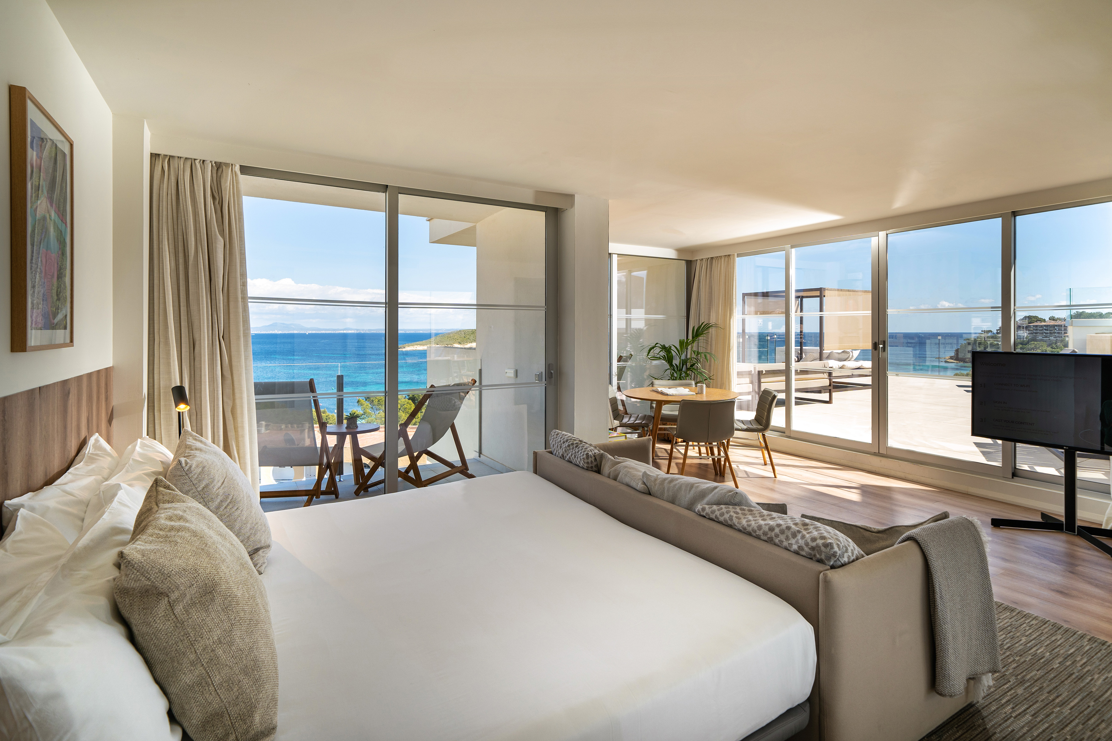 Modern hotel suite with panoramic sea view balcony.