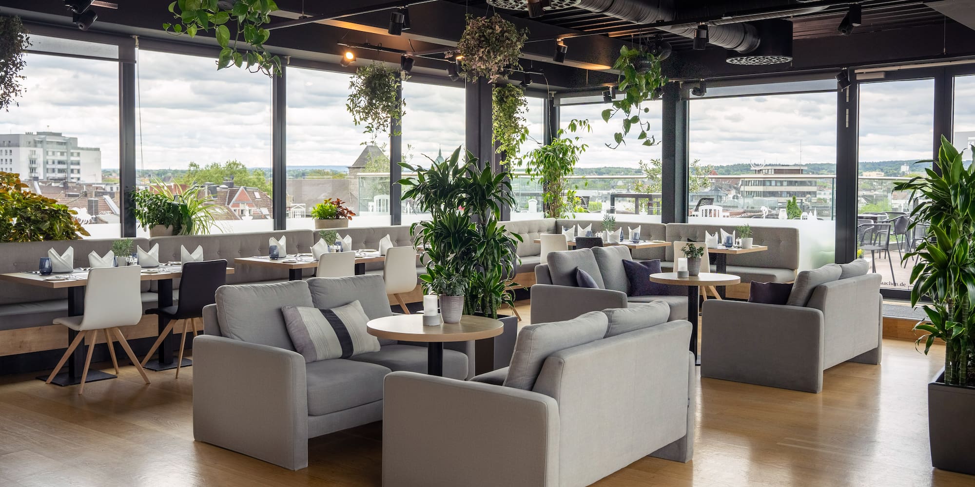 a room with tables and chairs and plants
