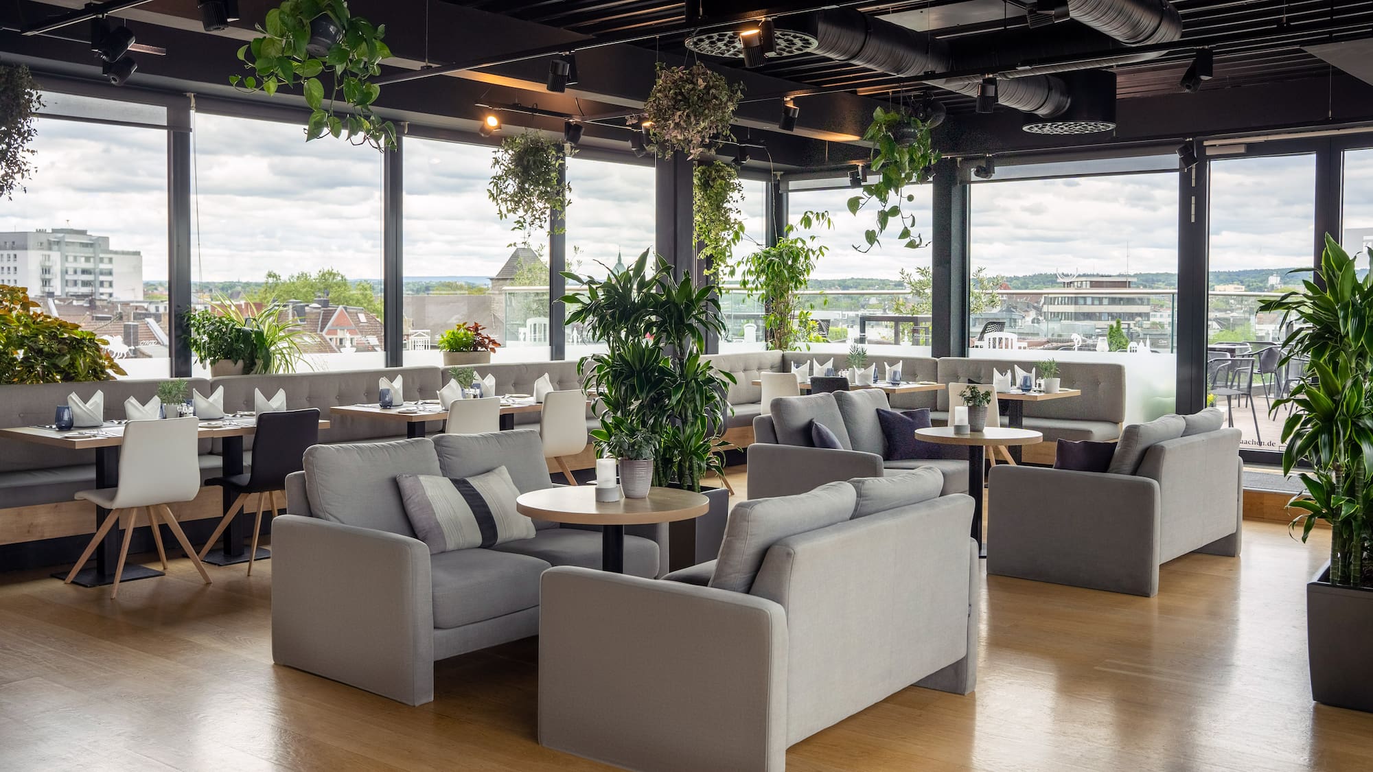 a room with tables and chairs and plants