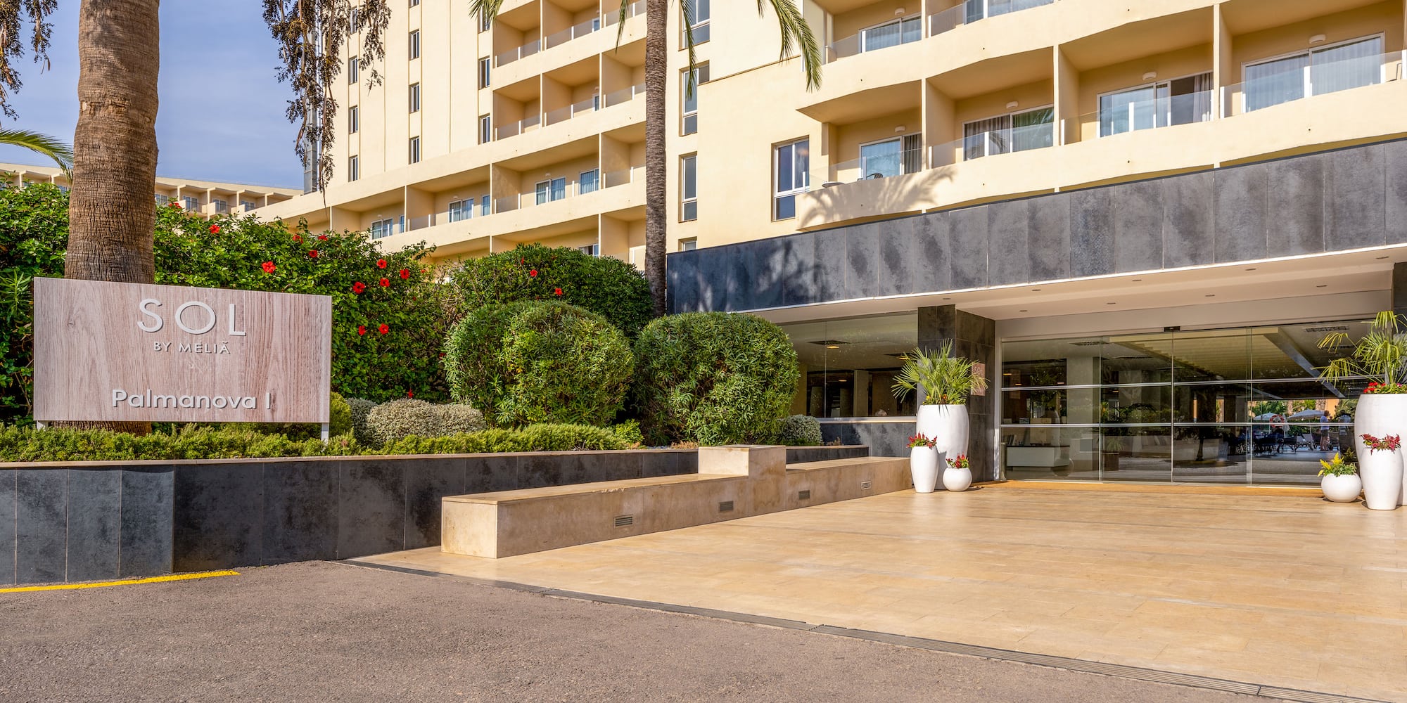 a building with palm trees and a parking lot