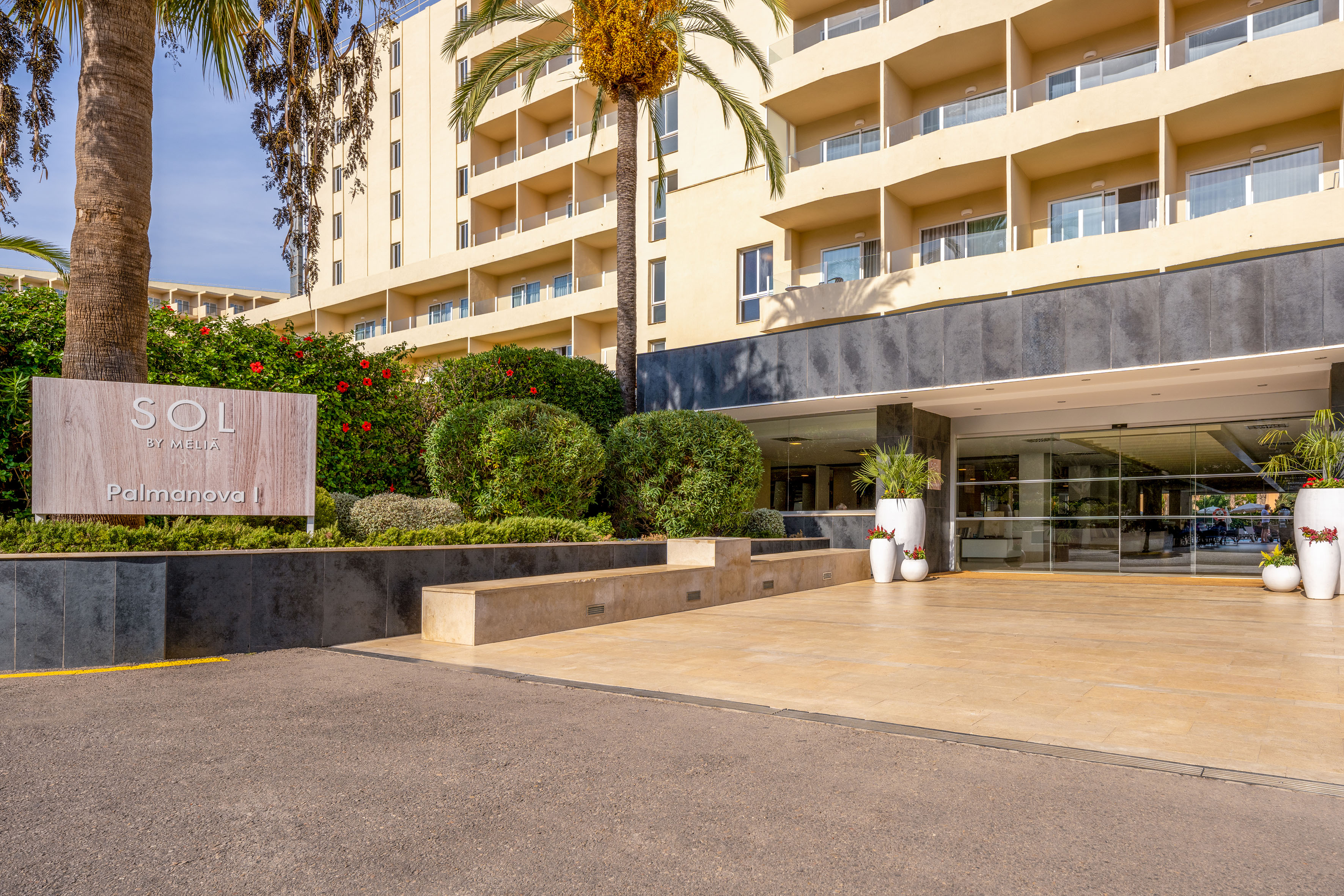 a building with palm trees and a parking lot