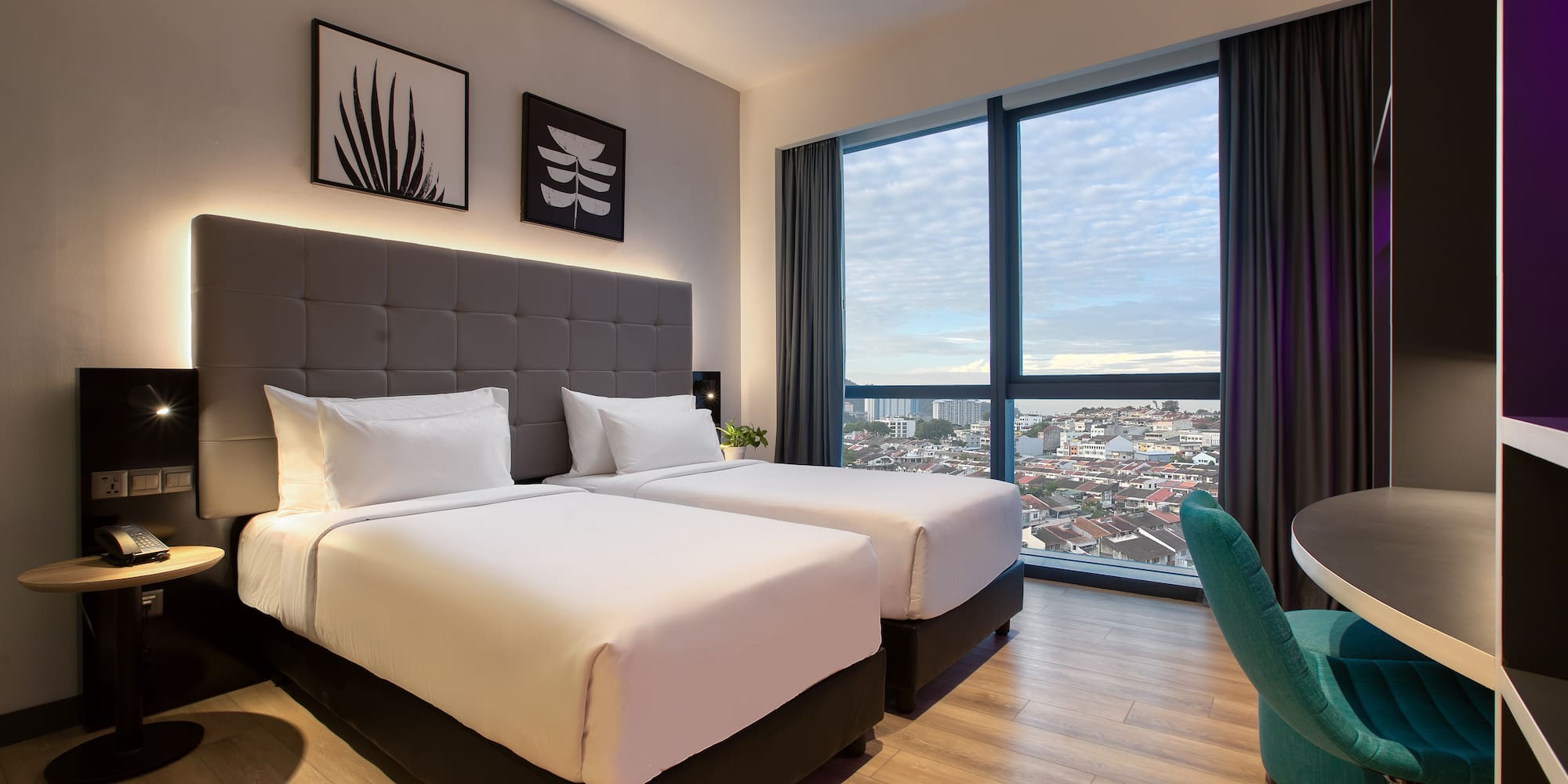 a room with two beds and a chair and a table