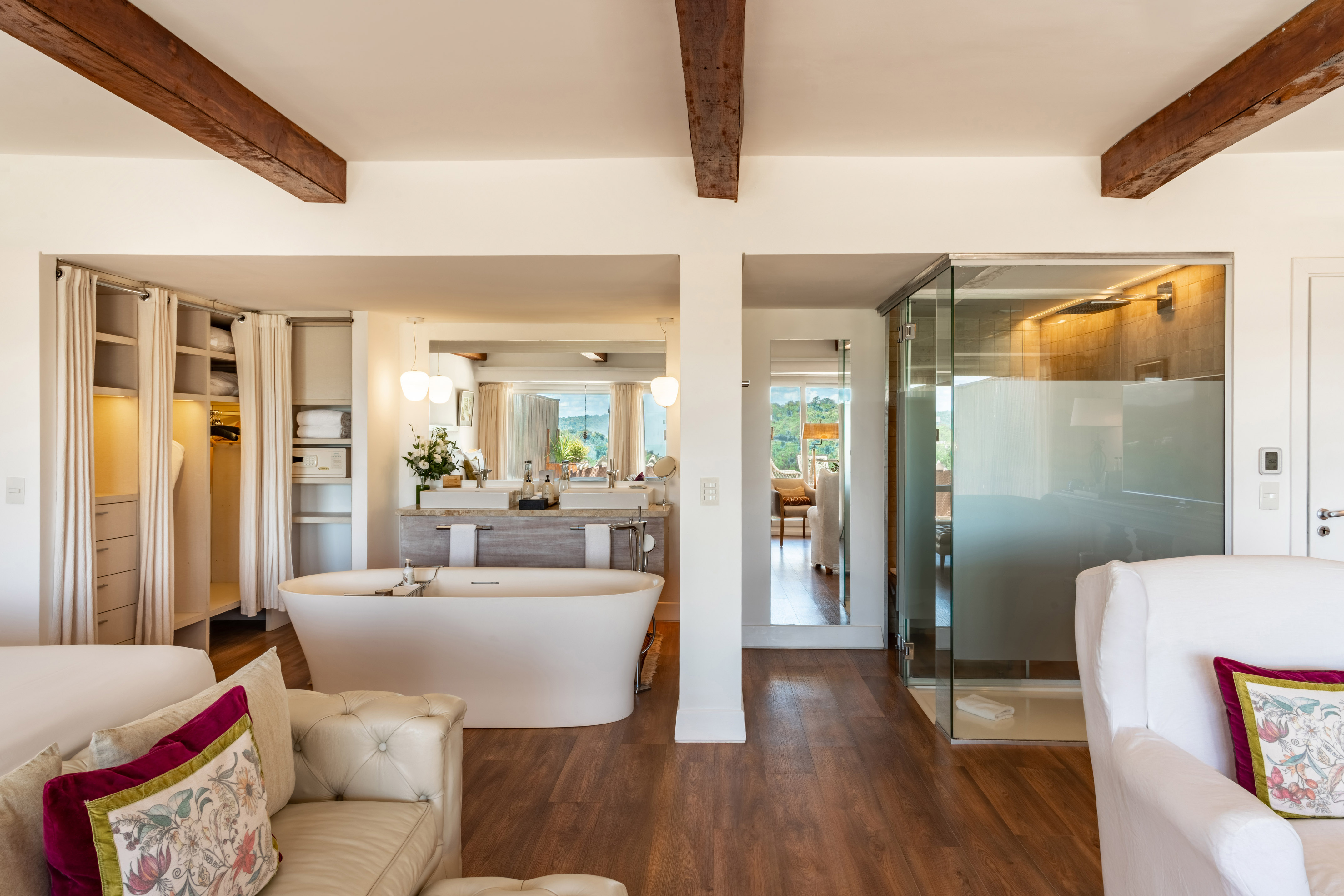 Luxury open-plan suite with freestanding tub, double vanity, and glass shower.